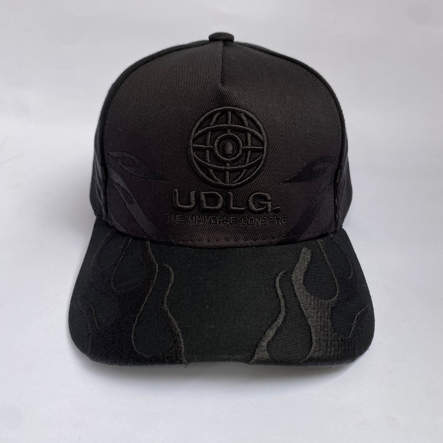 Gorra UDLG Negra con Bordado de Llamas y Frase “The Universe Conspire”